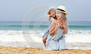 Happy family at beach. mother and child daughter hug at sea