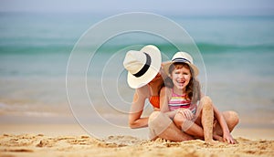 Happy family at beach. mother and child daughter hug at sea