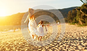 Happy family at beach. mother and child daughter run, laugh and