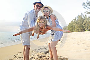 Happy family on the beach. People having fun on summer vacation. Father, mother and child against blue sea and beach background