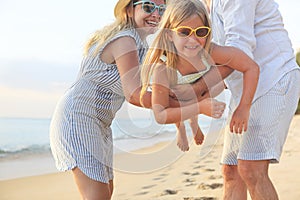 Happy family on the beach. People having fun on summer vacation. Father, mother and child against blue sea and beach background