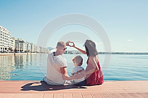 Happy family on the beach. People having fun on summer vacation. Father mother and child against blue sea and sky