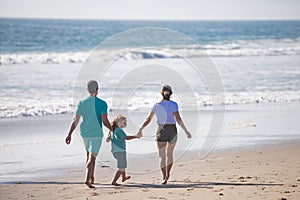 Happy family on the beach. People having fun on summer vacation. Father, mother and child on blue sea. Freedom carefree