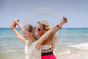 Happy family on the beach. People having fun on summer vacation. Mother and child against blue sea and sky background. Holiday