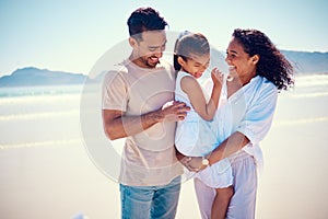 Happy family, beach smile and playing of a mother, father and girl together by the ocean. Nature, sea and love of a mom