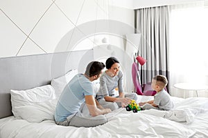 Happy family in bed at home or hotel room