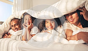 Happy family, bed and under blanket in home bedroom while comfortable, portrait and together. African woman, man and