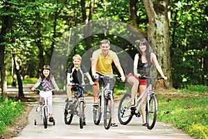 Happy family on a bicycles in the countryside