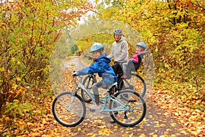 Happy family on bikes in autumn park