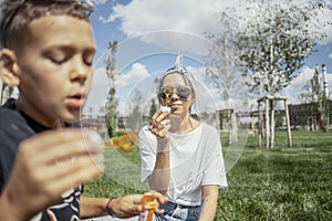 Happy family blowing bubbles outdoors in the park and having fun.