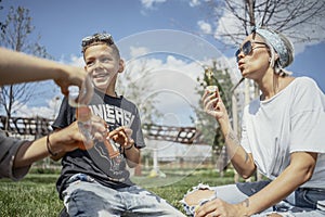 Happy family blowing bubbles outdoors in the park and having fun.