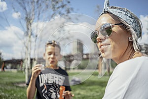 Happy family blowing bubbles outdoors in the park and having fun.