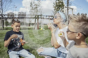 Happy family blowing bubbles outdoors in the park and having fun.