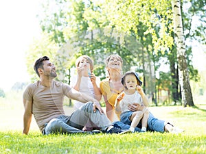 Happy family blowing bubbles in park