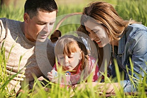 Happy family blowing soap bubbles in park