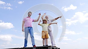 Happy family of boy kid with dad and grandad hold paper planes pointing fingers sky-high, aiming