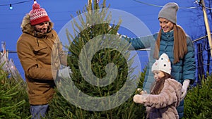 Happy family buying christmas tree at market