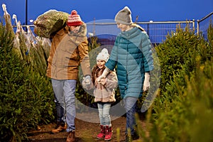 Happy family buying christmas tree at market