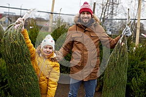 Happy family buying christmas tree at market