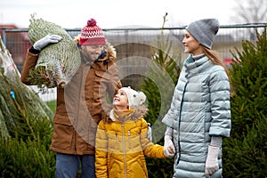 Happy family buying christmas tree at market