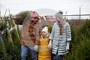 Happy family buying christmas tree at market