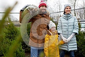 Happy family buying christmas tree at market