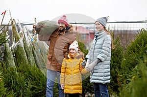 Happy family buying christmas tree at market