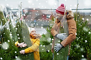 Happy family buying christmas tree at market