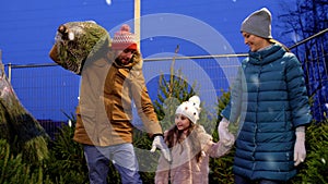 Happy family buying christmas tree at market