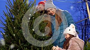 Happy family buying christmas tree at market