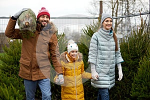 Happy family buying christmas tree at market