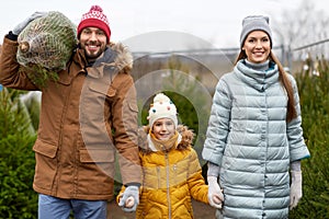 Happy family buying christmas tree at market