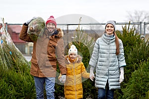 Happy family buying christmas tree at market