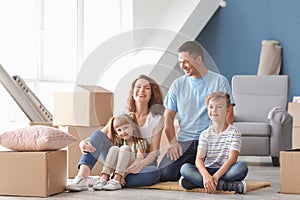 Happy family with cardboard boxes indoors. Moving into new house