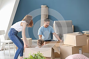 Happy family with cardboard boxes indoors. Moving into new house