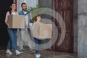 happy family with cardboard boxes and potted plant