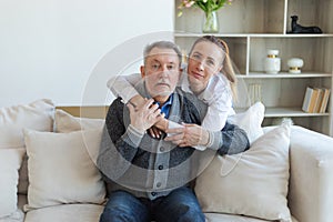 Happy family. Caring grown up daughter hugging loving older man father. Young woman embracing dad grandfather enjoying