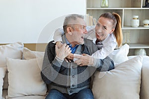 Happy family. Caring grown up daughter hugging loving older man father. Young woman embracing dad grandfather enjoying