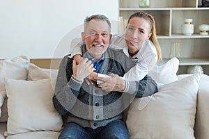 Happy family. Caring grown up daughter hugging loving older man father. Young woman embracing dad grandfather enjoying