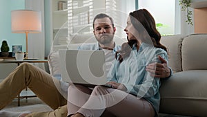 Happy family Caucasian young couple man woman husband wife at home floor in living room talking discuss choosing using