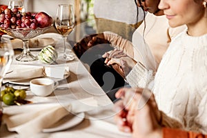 Happy family celebrate Thanksgiving day, sitting at table with roasted turkey and holiday traditional food, dishes.