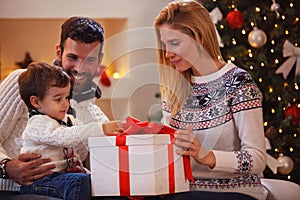 Happy family celebrating Christmas at home. father and mother gi