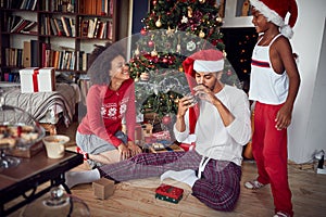 Family celebrating Christmas together. African American couple exchanging gifts