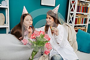 Happy family is celebrating little daughter`s Birthday. Attractive young woman with her charming daughter in pink dress at home.