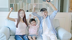 Happy family  celebrating success while watching TV at home