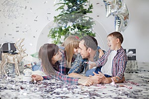 Happy family in checkered shirts rejoices at the new year, Christmas tree, gifts