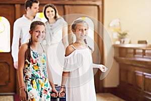 Happy family checking in hotel at reception desk