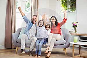 Happy family cheering while siting on sofa