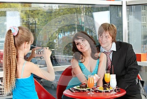 Happy family with child in cafe.