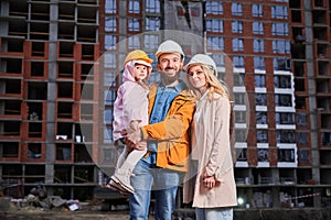 Happy family with child at construction site.